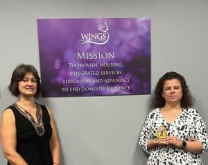 Shelley Welch, WINGS Sr. Manager of Annual Giving Fund with Anna Bard, WINGS Sr. Program Manager of Media Services & IT Relationships, with the Purple Ribbon Award