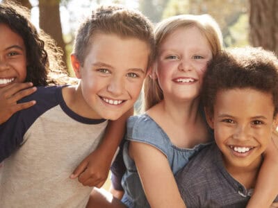 Portrait Of Children With Friends On Hiking Adventure In Woods