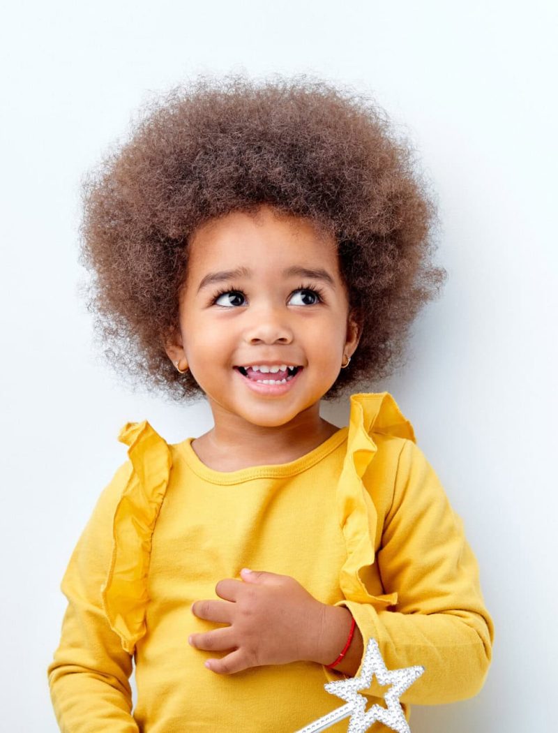 cheerful fluffy african american girl looking happy holding magic wand in hands cheerful fluffy african american girl looking happy holding magic wand in hands, laughing, isolated on white studio background. portrait. people diversity, african ethnicity, childhood concept